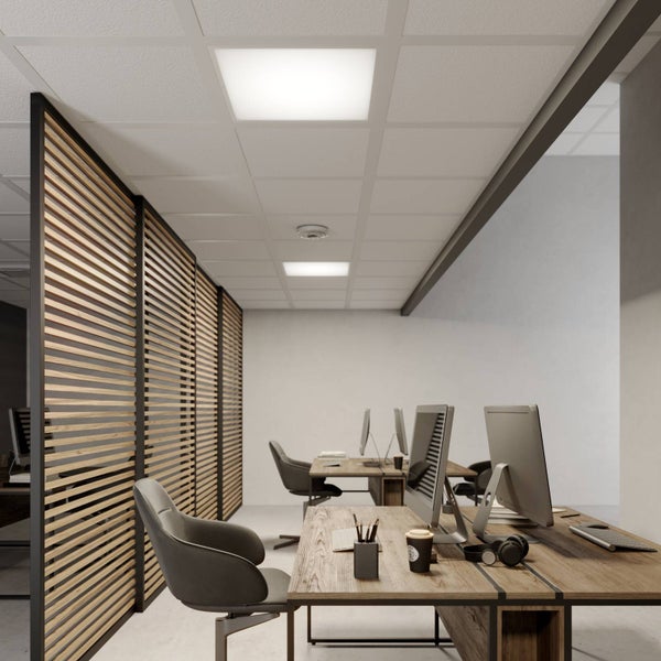 Modernes Büro mit Trennwänden aus Holzlamellen, Schreibtischen und hellen quadratischen LED-Panelen in einer weißen Rasterdecke.