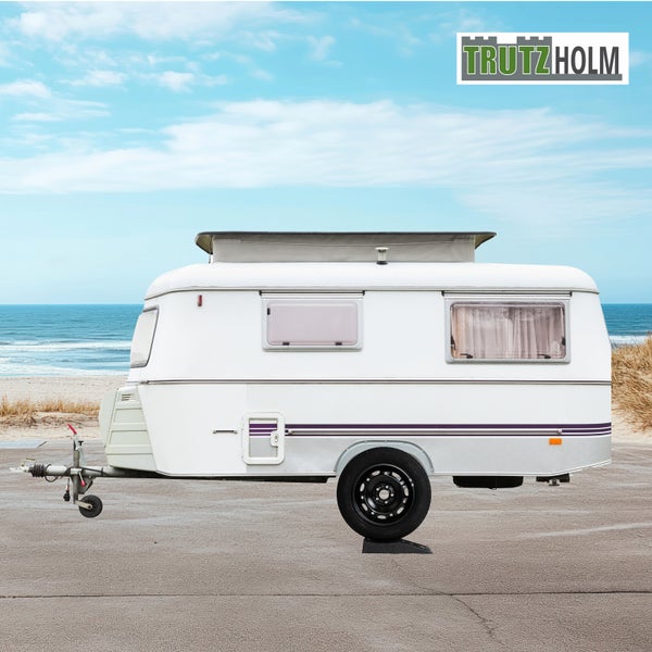 Weißer Wohnwagen mit Trutzholm Logo vor Strandkulisse