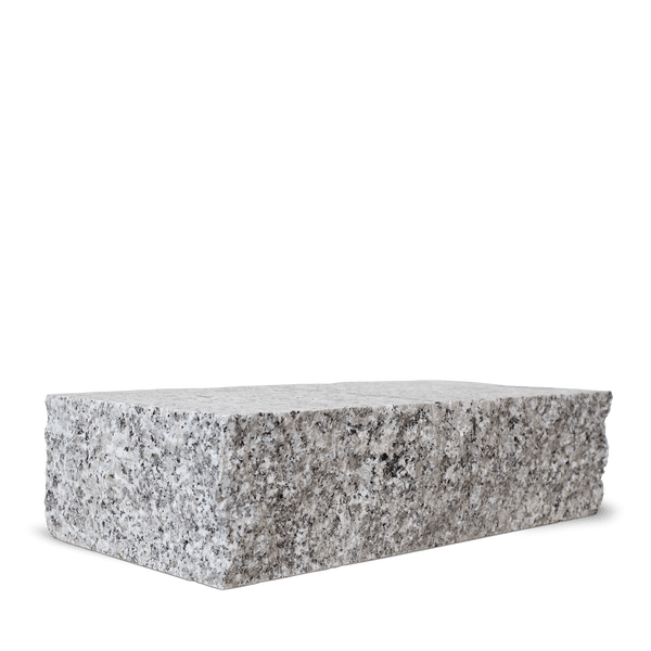 Zwei aufeinandergestapelte Granitblöcke mit naturrauer Oberfläche für den Mauerbau im Garten.