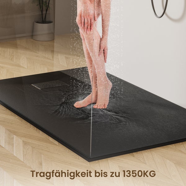 Schwarze Duschwanne mit stehender Person unter der Dusche im Badezimmer