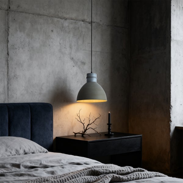 Moderne Pendelleuchte über einem Nachttisch in einem Schlafzimmer mit Betonwand.