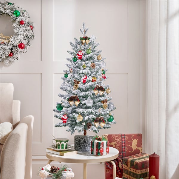 Dekorierter, künstlicher Weihnachtsbaum auf einem Beistelltisch mit Geschenken und Weihnachtskranz