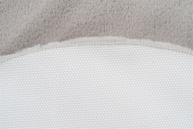 Nahaufnahme eines weichen Teppichs mit rutschfester Rückseite und geometrischem Muster.