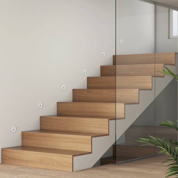 Moderne Holztreppe mit Glasgeländer und kleinen, runden Wandeinbauleuchten zur Stufenbeleuchtung.