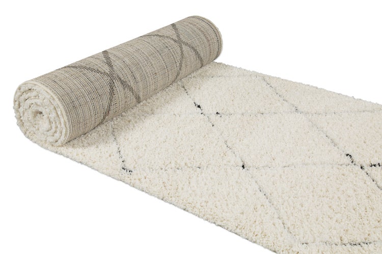 Hochflor-Teppich mit Rautenmuster, teilweise ausgerollt.