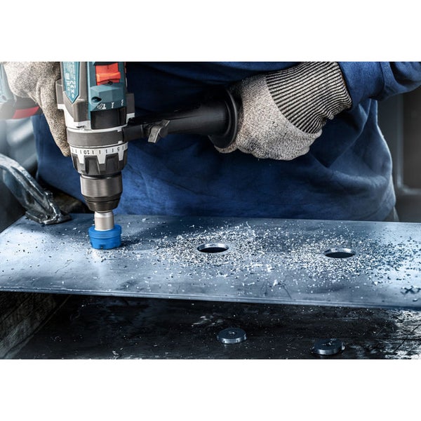 Eine Bohrmaschine mit Lochsäge bohrt ein Loch in ein Metallblech.