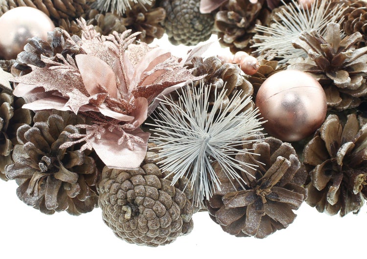 Weihnachtskranz aus Tannenzapfen dekoriert mit Kugeln und künstlichen Blüten als weihnachtliche Dekoration