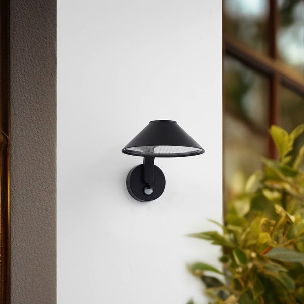 Schwarze Außenwandleuchte mit kegelförmigem Schirm und integriertem Bewegungsmelder.