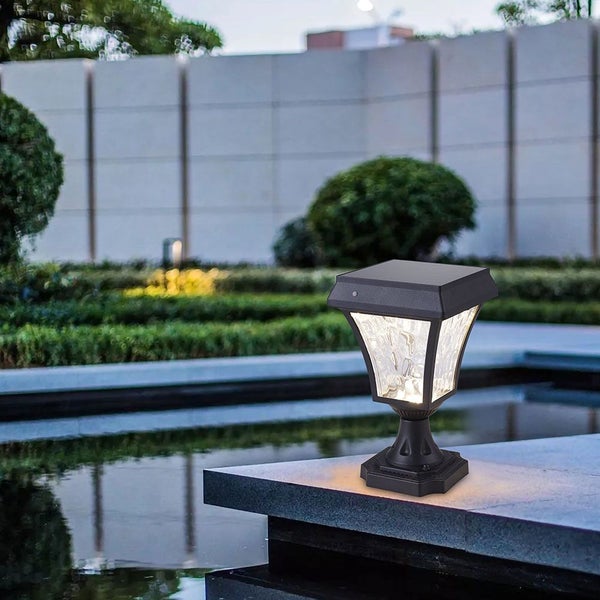 Solarleuchte für den Außenbereich auf einer Mauer mit Teich im Hintergrund