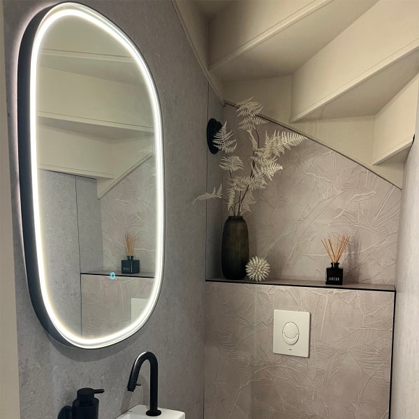 Modernes Badezimmer mit beleuchtetem Spiegel, Waschbecken und Dekoration