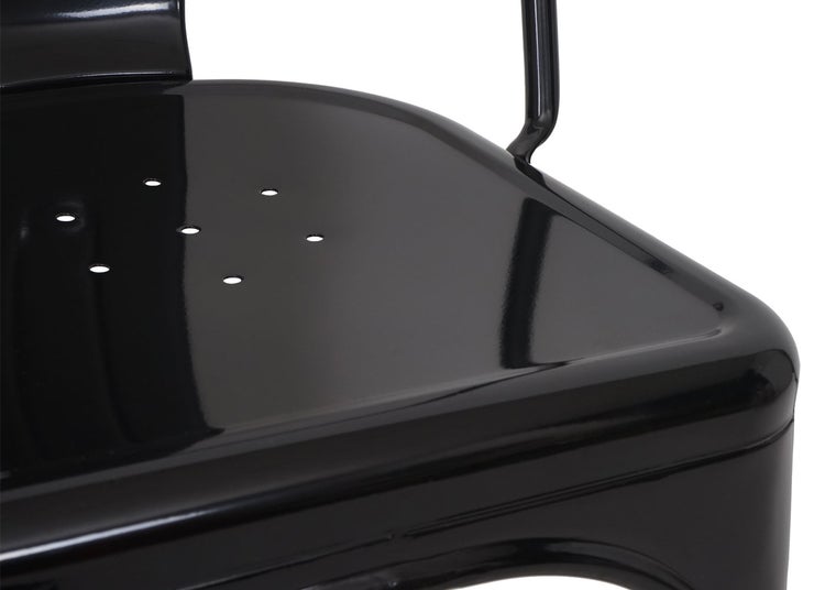 Detailansicht eines schwarzen Metallstuhls mit Löchern in der Sitzfläche
