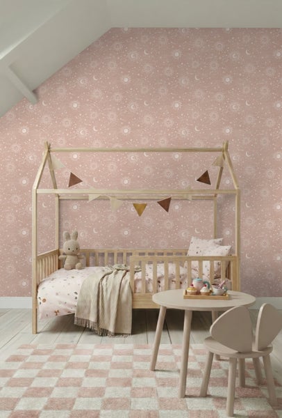 Kindertapete mit Sonne, Mond und Sternen in einem Kinderzimmer mit Holz-Hausbett und kleinem Spieltisch.