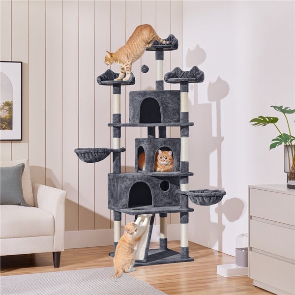 Mehrstöckiger Katzenkratzbaum mit Liegeflächen, Höhlen und Sisalstämmen im Wohnzimmer mit drei Katzen