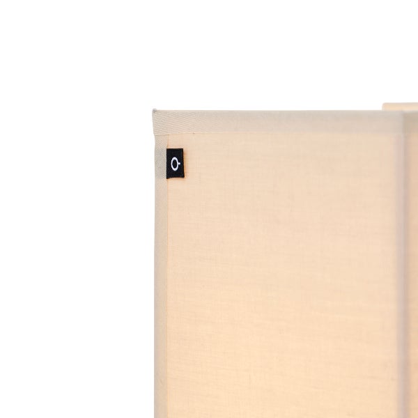 Detailansicht eines rechteckigen Lampenschirms aus Textil mit einem kleinen Markenetikett an der Ecke.