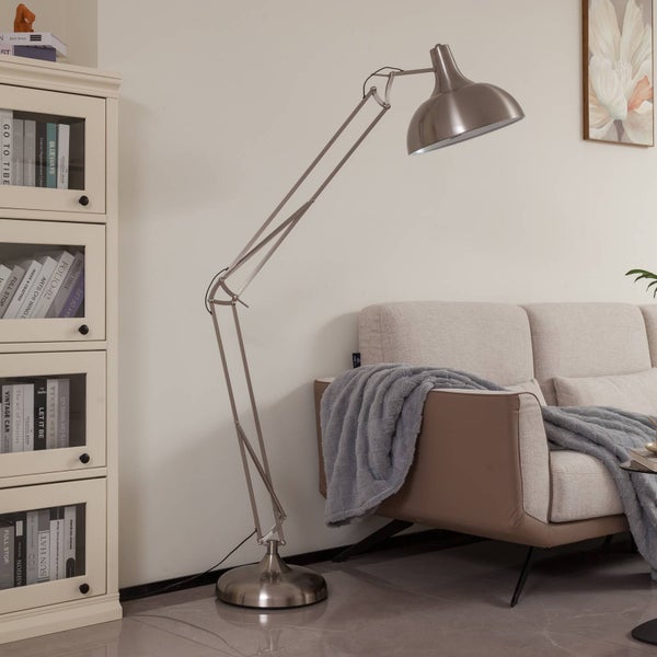 Stehlampe mit verstellbarem Arm neben einem Sofa und einem Bücherregal