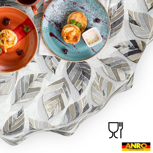 Tischdecke mit Blättermuster im modernen Design mit Tellern und Speisen. Lebensmittelecht Symbol und ANRO Deutsche Manufaktur Logo.