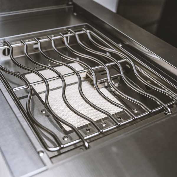 Infrarot-Seitenbrenner eines Gasgrills mit gewelltem Grillrost aus Edelstahl.