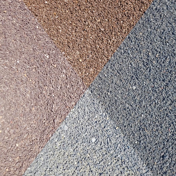 Modernes Gerätehaus aus Metall in Anthrazit mit Flachdach, Einzeltür mit Lichtausschnitt und seitlichem Anbau.