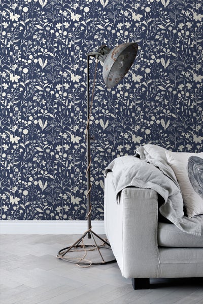 Raumansicht mit blumiger Tapete, Stehlampe und Sofa