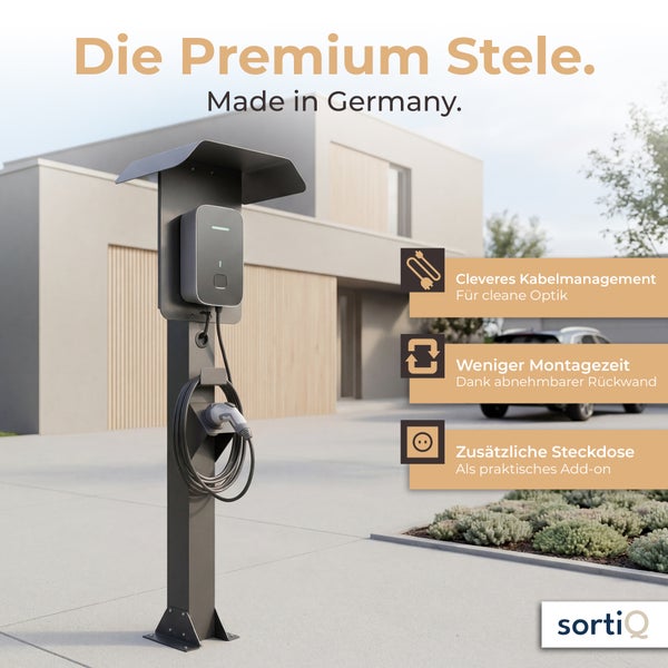 Sortiq Ladestation Stele für Wallboxen vor einem modernen Wohnhaus mit cleverem Kabelmanagement und zusätzlicher Steckdose.