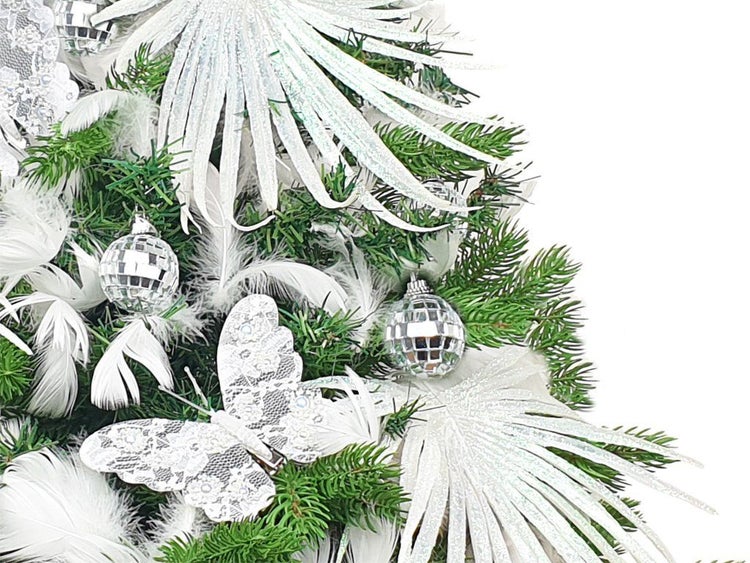 Weihnachtsbaum geschmückt mit Lametta Palmwedeln, Spiegelkugeln, Federn und Schmetterling als festlicher Baumschmuck für die Weihnachtszeit