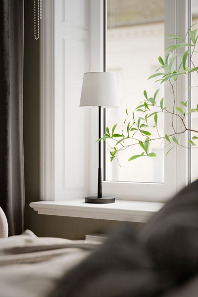 Dekorative Wohnszene mit Stehlampe, Fenster und Zimmerpflanze