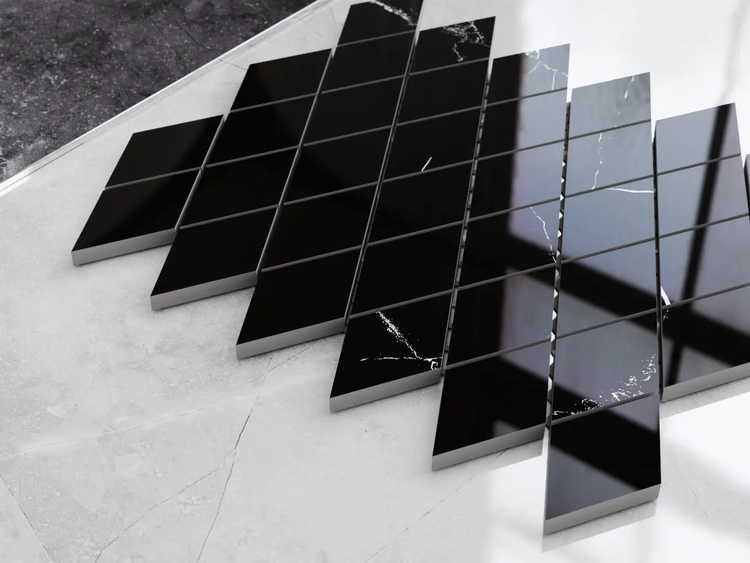 Schwarze Mosaikfliesen in Rautenform mit Marmoroptik und glänzender Oberfläche.