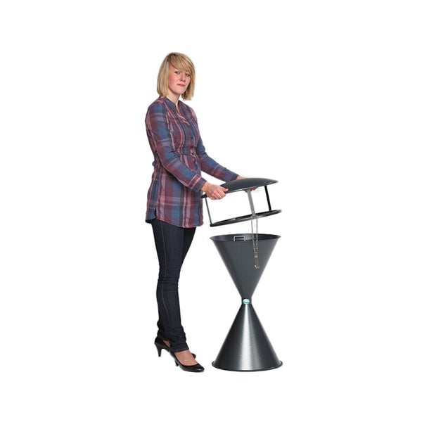 Eine Frau hebt den Deckel eines kegelförmigen Standaschers aus Metall an, um das Innere zu zeigen.