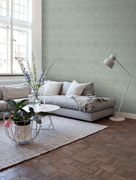 Wohnzimmer mit Sofa, Tisch, Lampe und gemusterter Tapete