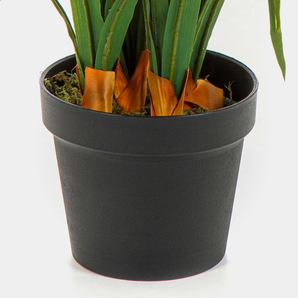 Kunstblumenstrauß mit vielfältigen Blüten und grünem Blattwerk in einer schlichten grünen Vase.