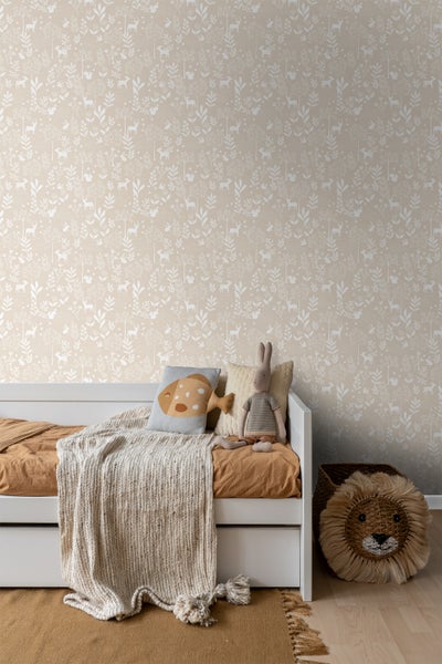 Kinderzimmer mit gemusterter Tapete, weißem Bett, dekorativen Kissen, Überwurf und einem geflochtenen Löwenkorb.