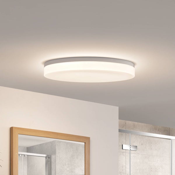 Runde LED-Deckenleuchte in flachem Design, warmweißes Licht, montiert in einem hellen Badezimmer mit Spiegel und Glasdusche.