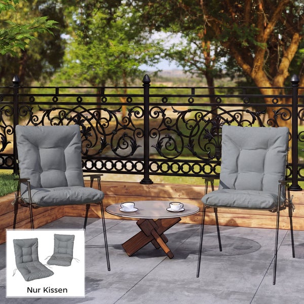 Zwei graue Hochlehner-Auflagen auf Gartenstühlen auf einer hellen Terrasse mit dekorativem Metallzaun, Holzeinfassung und kleinem Beistelltisch.