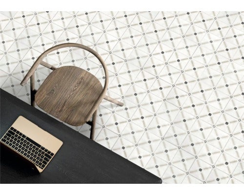 Boden mit geometrisch gemusterten Fliesen in einem hellen Raum mit schwarzem Schreibtisch, Laptop und Holzstuhl.