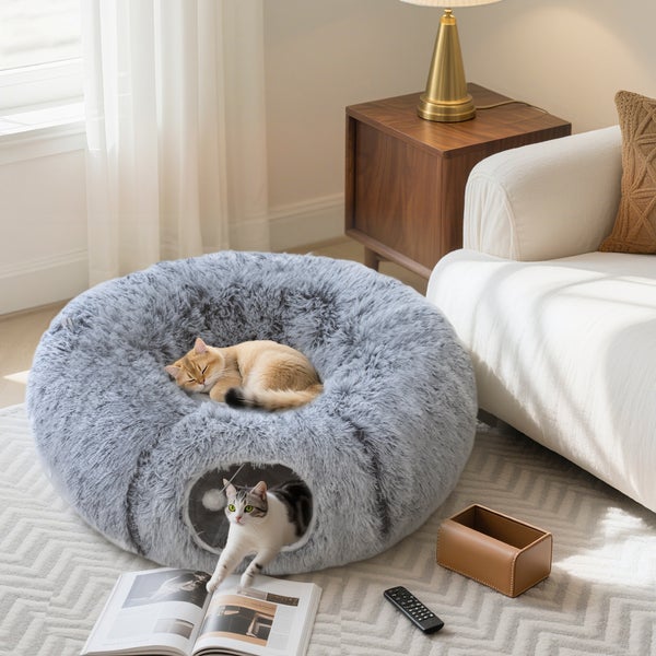 Graues Katzenbett mit zwei Katzen in einem Wohnzimmer.