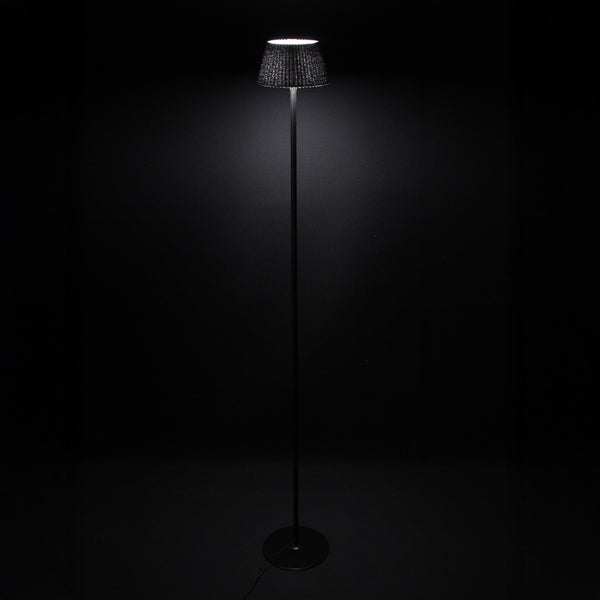 Stehlampe mit Lampenschirm auf dunklem Hintergrund