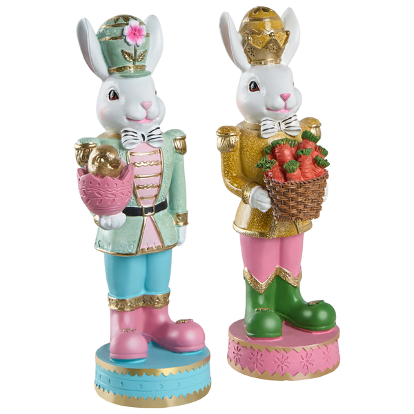 Zwei dekorative Osterhasen-Figuren im Nussknacker-Stil, einer hält ein Ei mit Küken, der andere einen Korb mit Karotten.