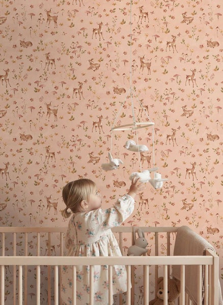 Kindertapete mit Waldmotiven wie Rehen und Pilzen im Kinderzimmer mit Babybett und Mobile