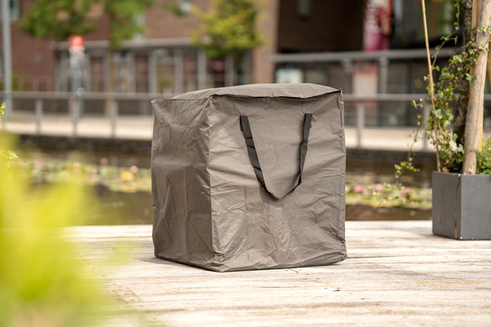 Graue Schutzhülle für Gartenmöbel mit Reißverschluss und Tragegriffen auf einer Holzterrasse