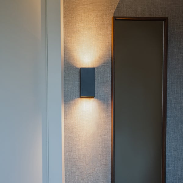 Wandleuchte neben einem Spiegel an einer Wand