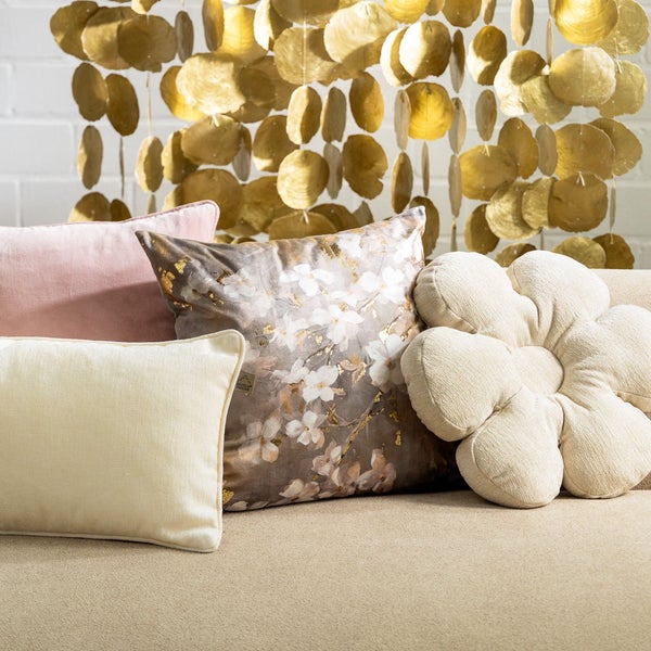 Dekorative Kissen in verschiedenen Formen und Designs auf einem Sofa.