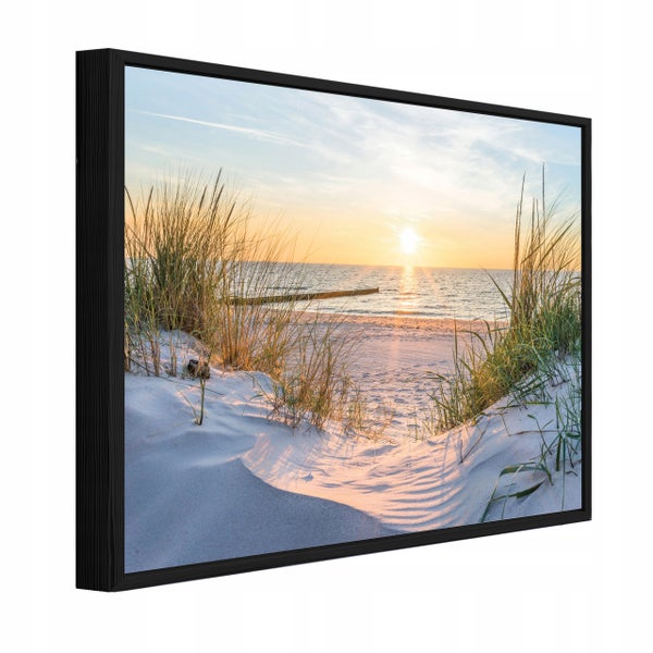 Wandbild mit Strandmotiv bei Sonnenuntergang in einem schwarzen Rahmen.