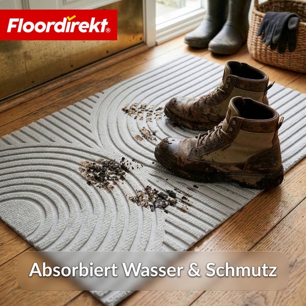 Floordirekt Logo. Schmutzfangmatte mit strukturierter Oberfläche und schlammigen Arbeitsstiefeln auf Holzboden. Absorbiert Wasser und Schmutz.