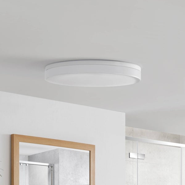 Runde weiße LED-Deckenleuchte montiert in einem hellen modernen Badezimmer mit Holzspiegel und Glasdusche.
