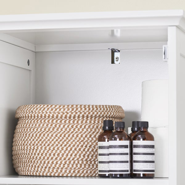 Innenraum eines Badezimmerschranks mit Korb, Flaschen und Toilettenpapier