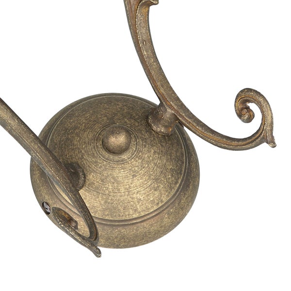 Detailaufnahme einer bronzefarbenen Wandleuchte mit floralen Verzierungen