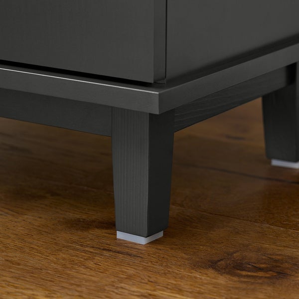 Detailansicht eines grauen Unterschranks mit Füßen auf einem Holzboden