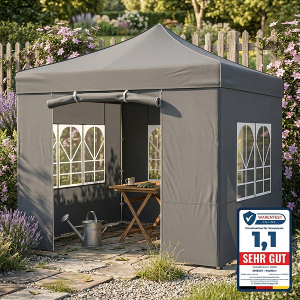 Grauer Gartenpavillon mit Bogenfenstern und Seitenwänden auf einer Terrasse, mit Holztisch und Gießkanne, ausgezeichnet mit sehr gutem Testergebnis.