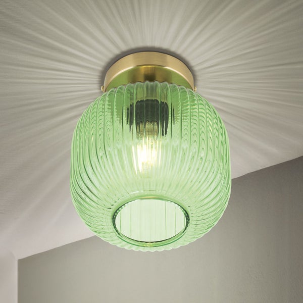Grüne Glas-Deckenleuchte mit geripptem Design und goldfarbener Halterung an der Decke.