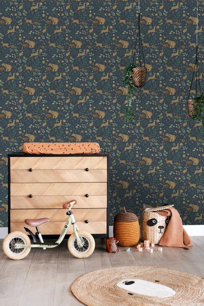 Kinderzimmer mit einer Kommode, einem Laufrad und einer Tapete mit Tiermotiven.